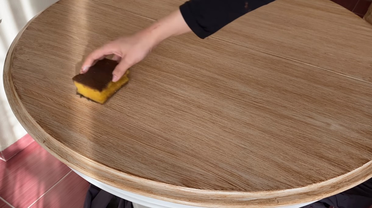 Eskitme kremi çok koyu bir kahverengi olduğu için bu rengi açmamız gerekiyor. Glazing medium ve eskitme kremini karıştırdıktan sonra fırçamıza alıyoruz, ardından gelişigüzel bir şekilde tüm masaya uyguluyoruz.