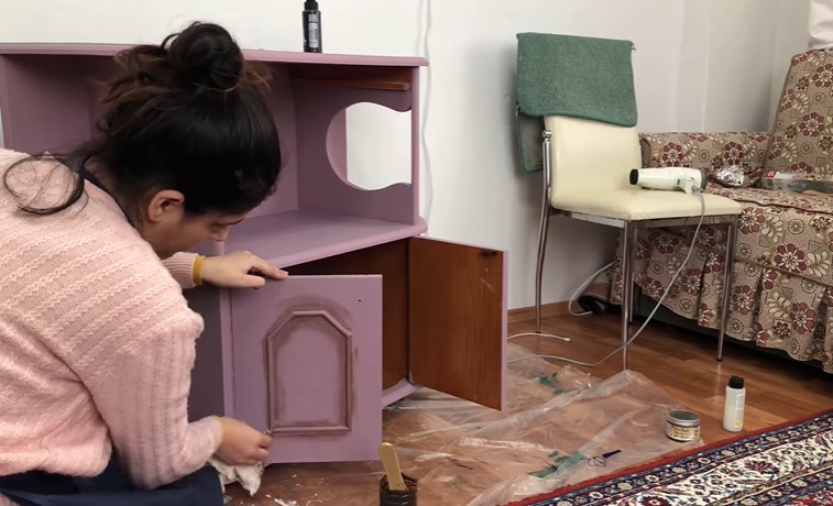 Espresso kremini mobilyanın alt kapaklarına da uyguluyoruz. Nemli bezle silmeye devam ediyoruz.
